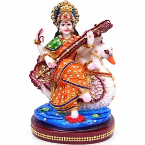 Buji Saraswati figurine playing a veena beside a white swan, studio view