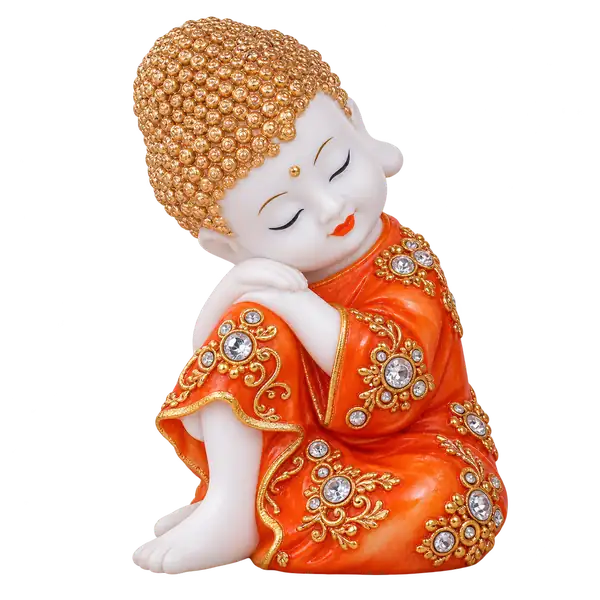 Orange resting baby monk figurine with gold floral details on a transparent background